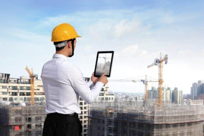 Construction Manager taking a picture of the construction site with a tablet