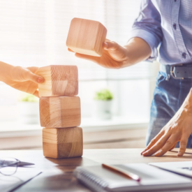 man and women stacking wood blocks on an office desk|graph on why and how to include users in design|graph on why and how to include users in design