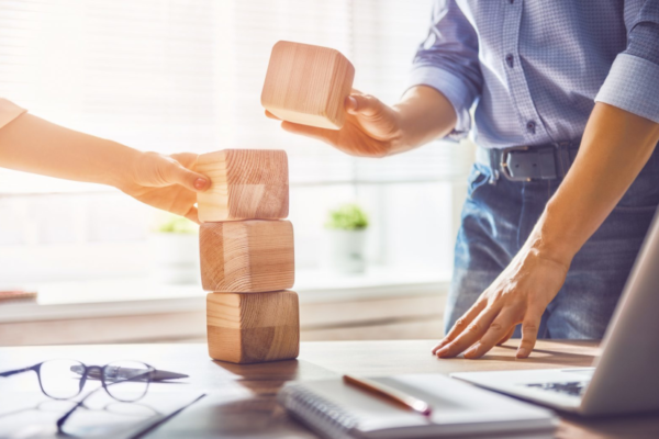 man and women stacking wood blocks on an office desk|graph on why and how to include users in design|graph on why and how to include users in design