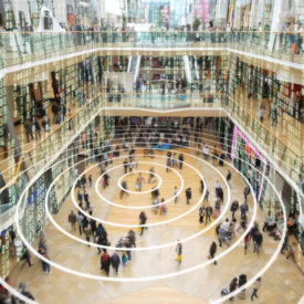 Radio waves spreading out from a mobile phone in a shopping mall with matrix style data layered on top.|Radio waves spreading out from a mobile phone in a shopping mall with matrix style data layered on top.