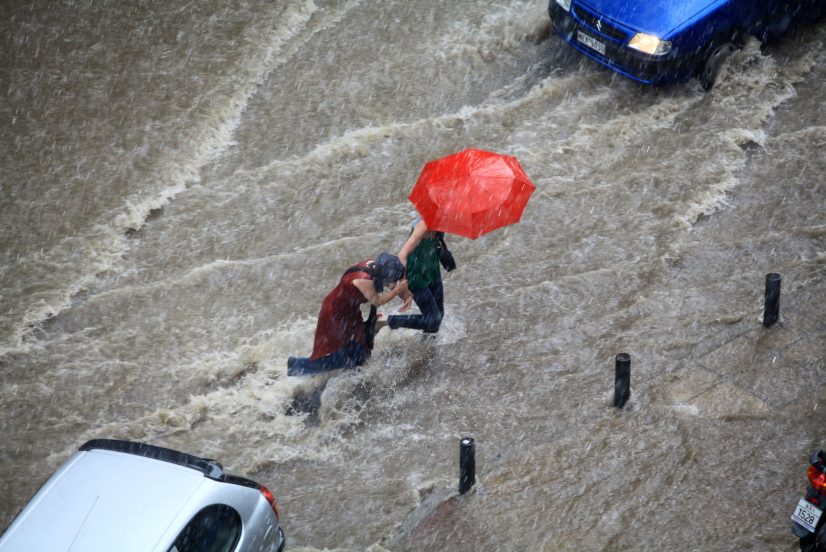 People trying to cross a flooded road