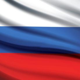Wehende russische Flagge|Waldfläche in dem Stadtbild im Hintergrund rausragt