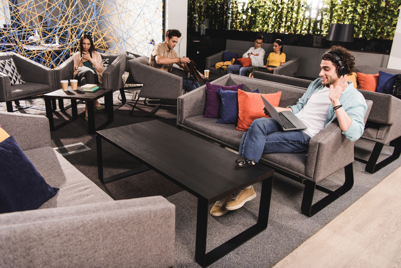 Employees relaxing and working in a hybrid office space.