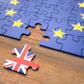 EU Flagge als Puzzle mit Puzzlestück mit britischer Flagge entfernt daneben liegt|Statistik auf Englisch: Arbeitskräfte Verlust Brexit