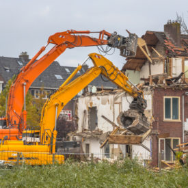 Two Demolition cranes demolishing old row of houses in the Netherlands