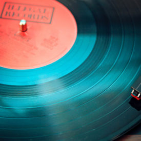 A green record playing songs on a record player.
