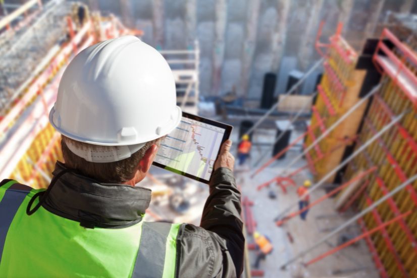image of a construction worker on site with a project document on tablet
