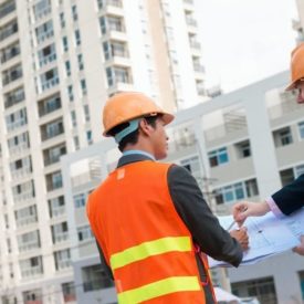 two construction professionals in construction site with checklist